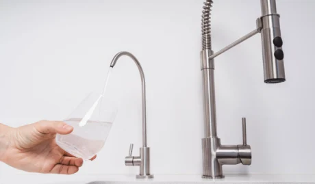 Person Pouring Filtered Water Into Glass Cup